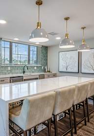 A kitchen with a long table and chairs.