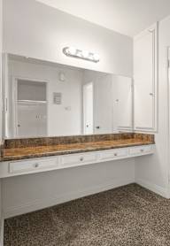 A white closet with a bench and a hanger.