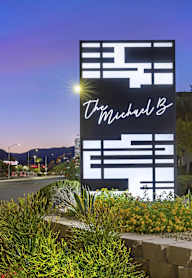 a sign for a hotel on the side of a street at night