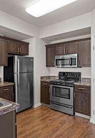 A kitchen with a sink, stove, and refrigerator.