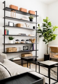 a living room with a couch and a desk and a window