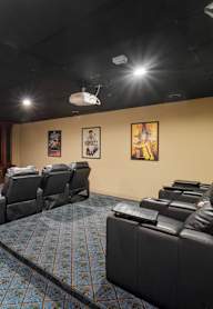 a large screening room with leather seats and a projector screen