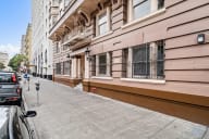 a street view of a building with a sidewalk and a parking meter
