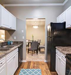 A kitchen with black appliances and white cabinets at Austin Chase Apartments, Macon, Georgia
