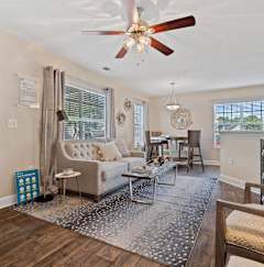 A living room with a couch, chairs, and a rug.