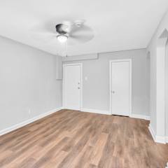 A room with a ceiling fan and wooden flooring.