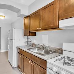 A kitchen with white appliances and wooden cabinets.