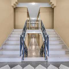 A staircase with a metal railing and a checkered floor.