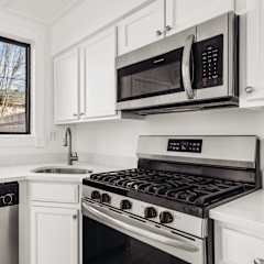 A kitchen with white cabinets and a black stove top oven.