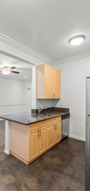 A kitchen with wooden cabinets and a black refrigerator.