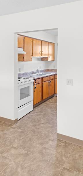 A kitchen with white walls and a tiled floor.