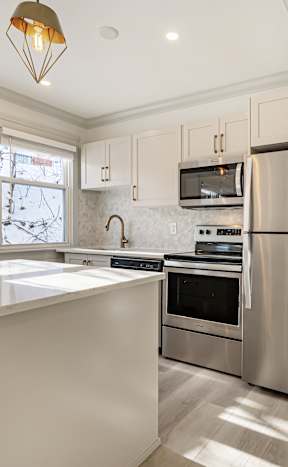 A kitchen with a stainless steel refrigerator and a white countertop.