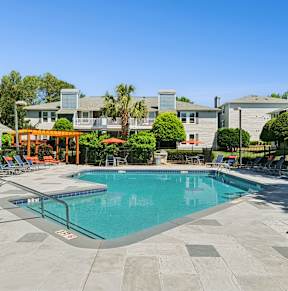 Outdoor swimming pool with lounge seating and shaded pavilion at Palmetto Place Apartments in Taylors, SC