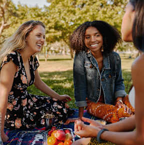 Three women having a picnic in a park.