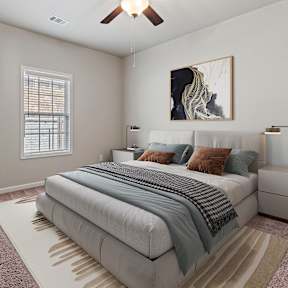 A bedroom with a large bed, a ceiling fan, and a painting on the wall.