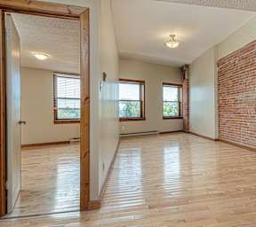 A room with wooden floors and a brick wall.