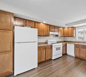 A kitchen with wooden cabinets and a white refrigerator.