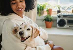 a woman holding a small dog in her lap at The Courtyards of Chanticleer, Virginia Beach, VA