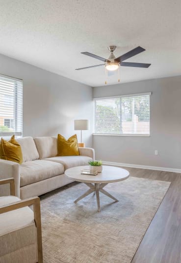 a living room with a couch and a ceiling fan