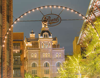 A building with a sign that says Pearl is lit up at night.