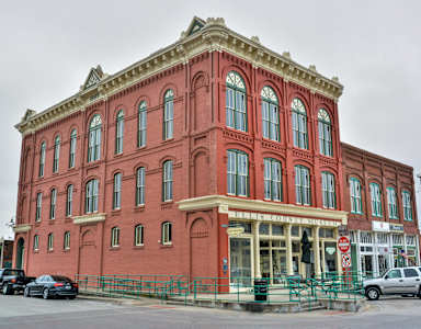 A red building with a green fence in front.