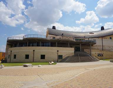 A large building with a curved roof and a balcony on the second floor.