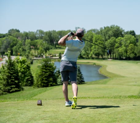 a man swinging a golf club on a golf course