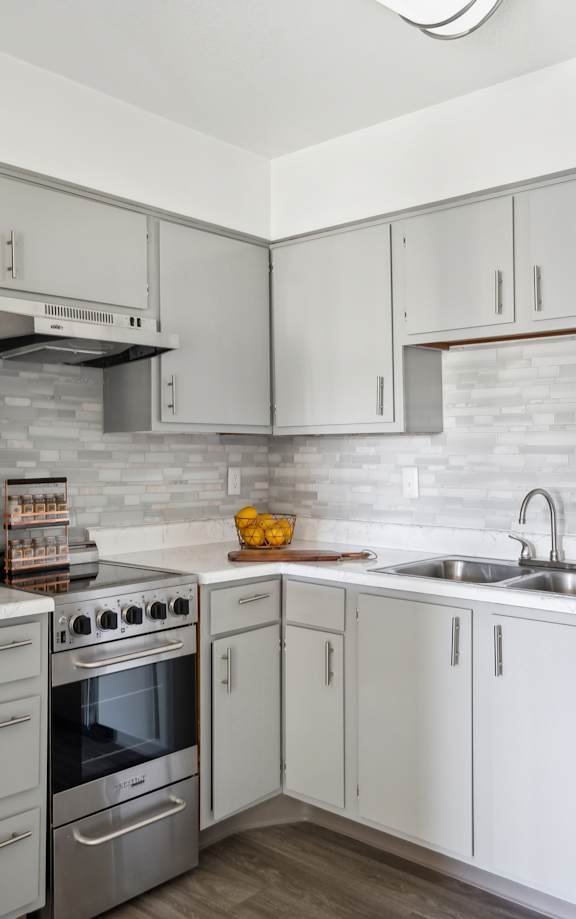 A modern kitchen with white cabinets and a stainless steel refrigerator.