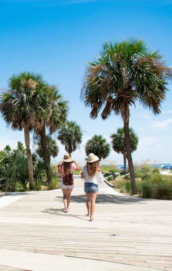 A boardwalk with a row of umbrellas and a sign that says "Rodeo".
