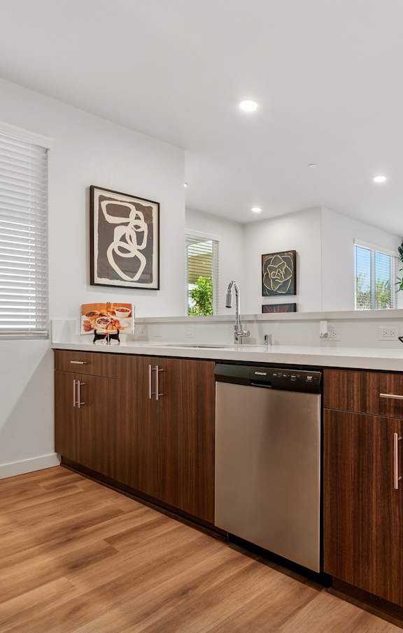 A modern kitchen with a stainless steel refrigerator and wooden cabinets.at The Park on Washington, California