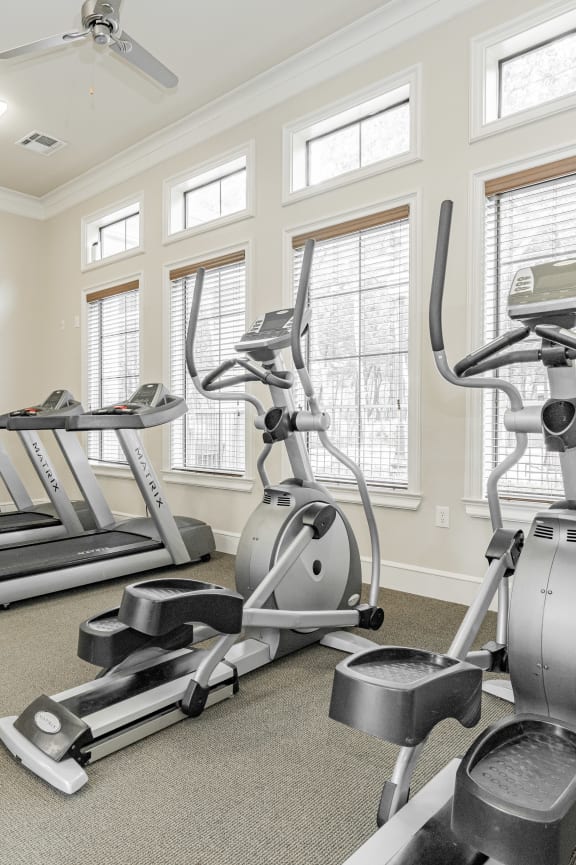 a gym with weights and cardio machines in it