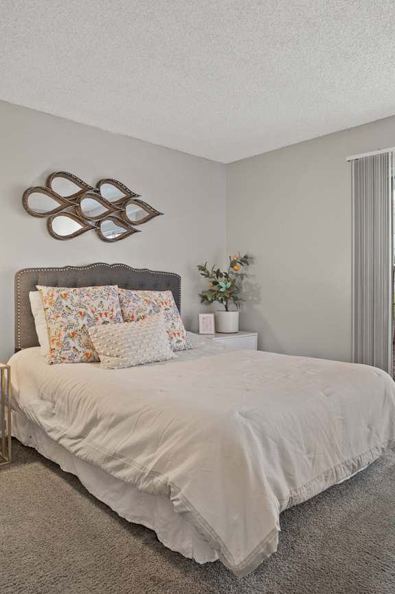 A bedroom with a bed, chair, and lamp.