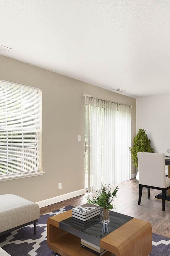 an empty living room with windows and a door to a bathroom