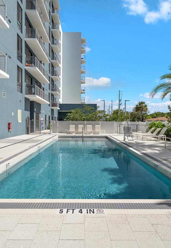 A swimming pool in front of a building with the number 5 on it.