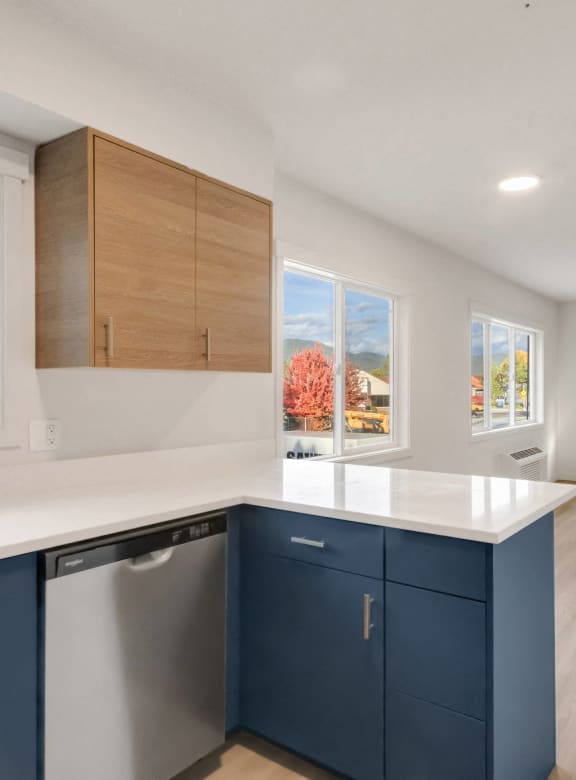 a kitchen with a large window and a sink and a refrigerator