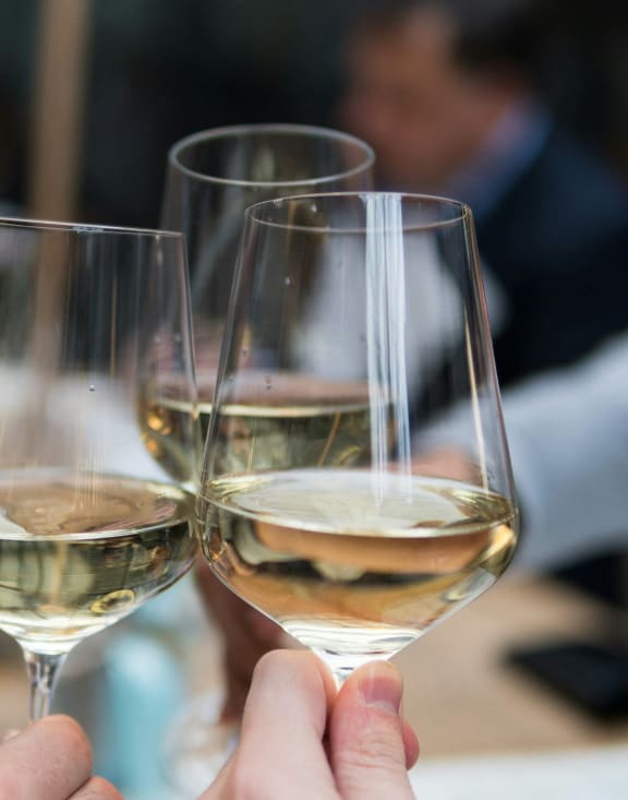 two people holding wine glasses in a restaurant