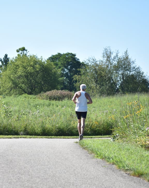 a woman running down a path in a field