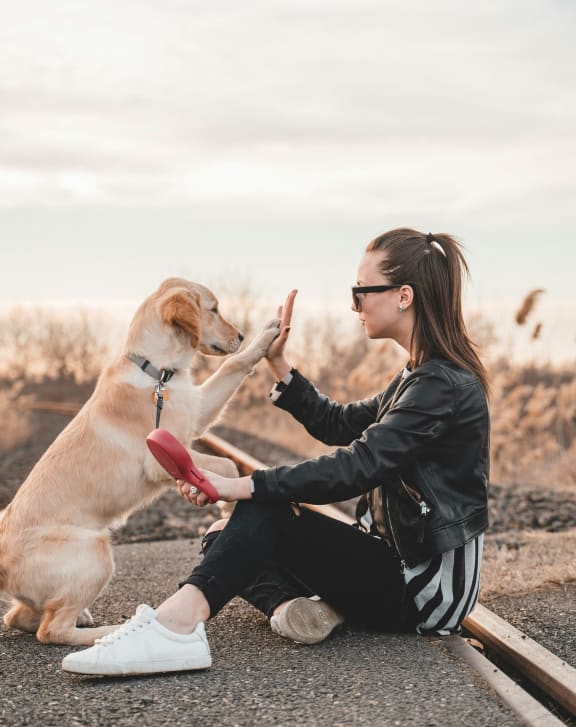 a woman sitting on the ground with her dog