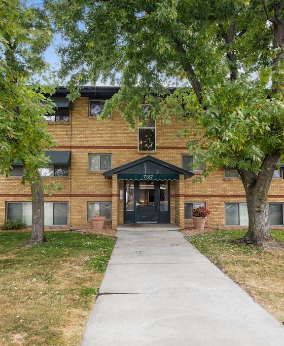 A brick building with a tree in front of it.