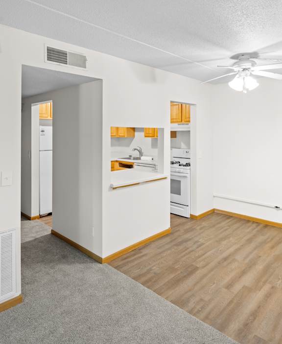 A kitchen with white cabinets and a wooden floor.