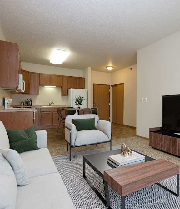 A living room with a white couch, a wooden coffee table, and a flat screen TV.