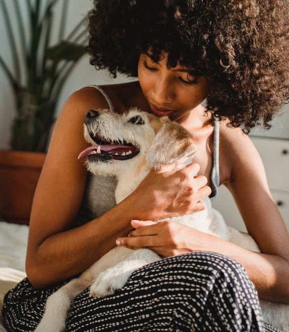 a woman sitting on a bed with her dog