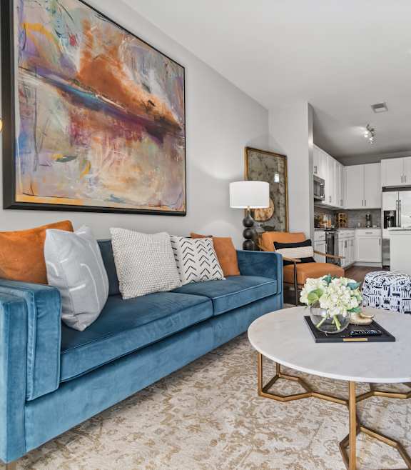 A modern living room with a blue couch and a coffee table. at 1010 Dilworth Apartments, Charlotte, North Carolina