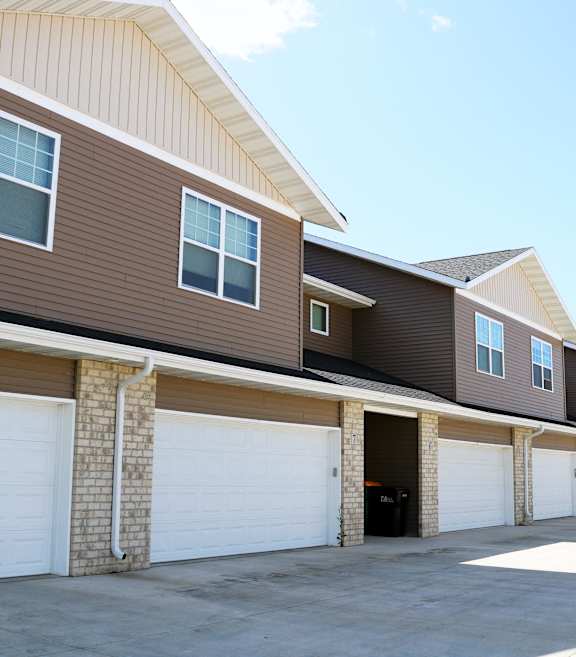 A long row of garage doors in front of houses.