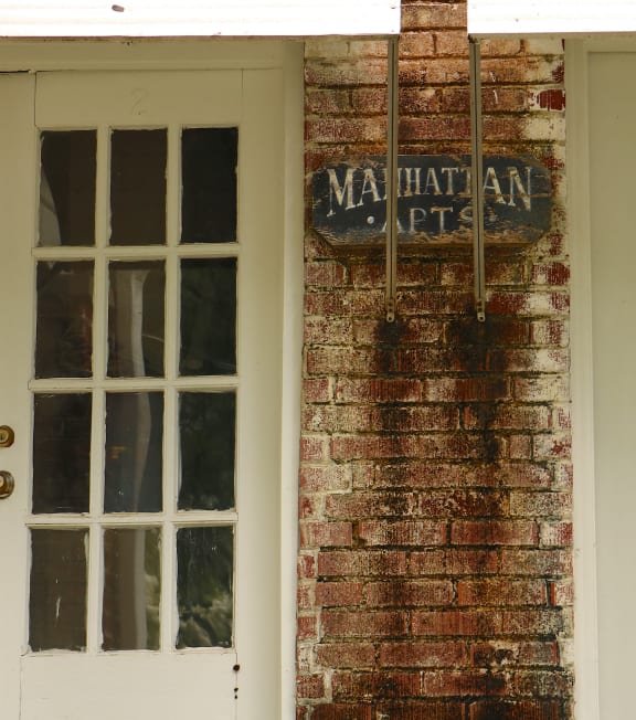 a brick building with a door and a nathaniel art sign