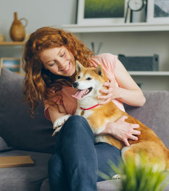a woman sitting on a couch with her dog a woman sitting on a couch with her dog at Cycle Apartments, Colorado, 80525