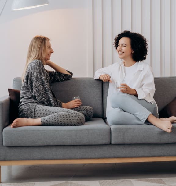 two women sitting on a couch talking