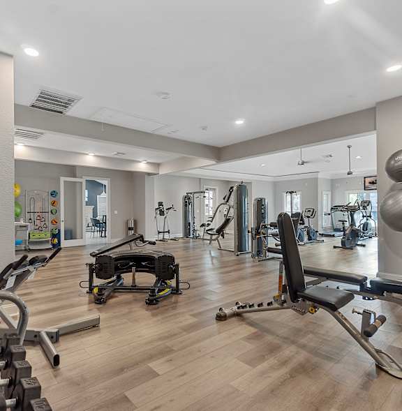 A spacious gym with a variety of equipment including treadmills, weights, and exercise machines.