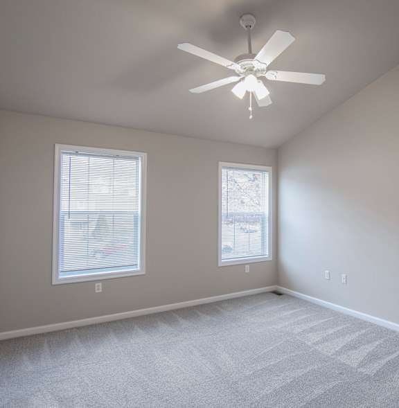 A room with a ceiling fan and a window.