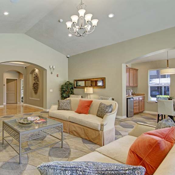 The resident lounge at Asbury Park with couches and coffee tables, with a kitchenette and dining area in the background.  